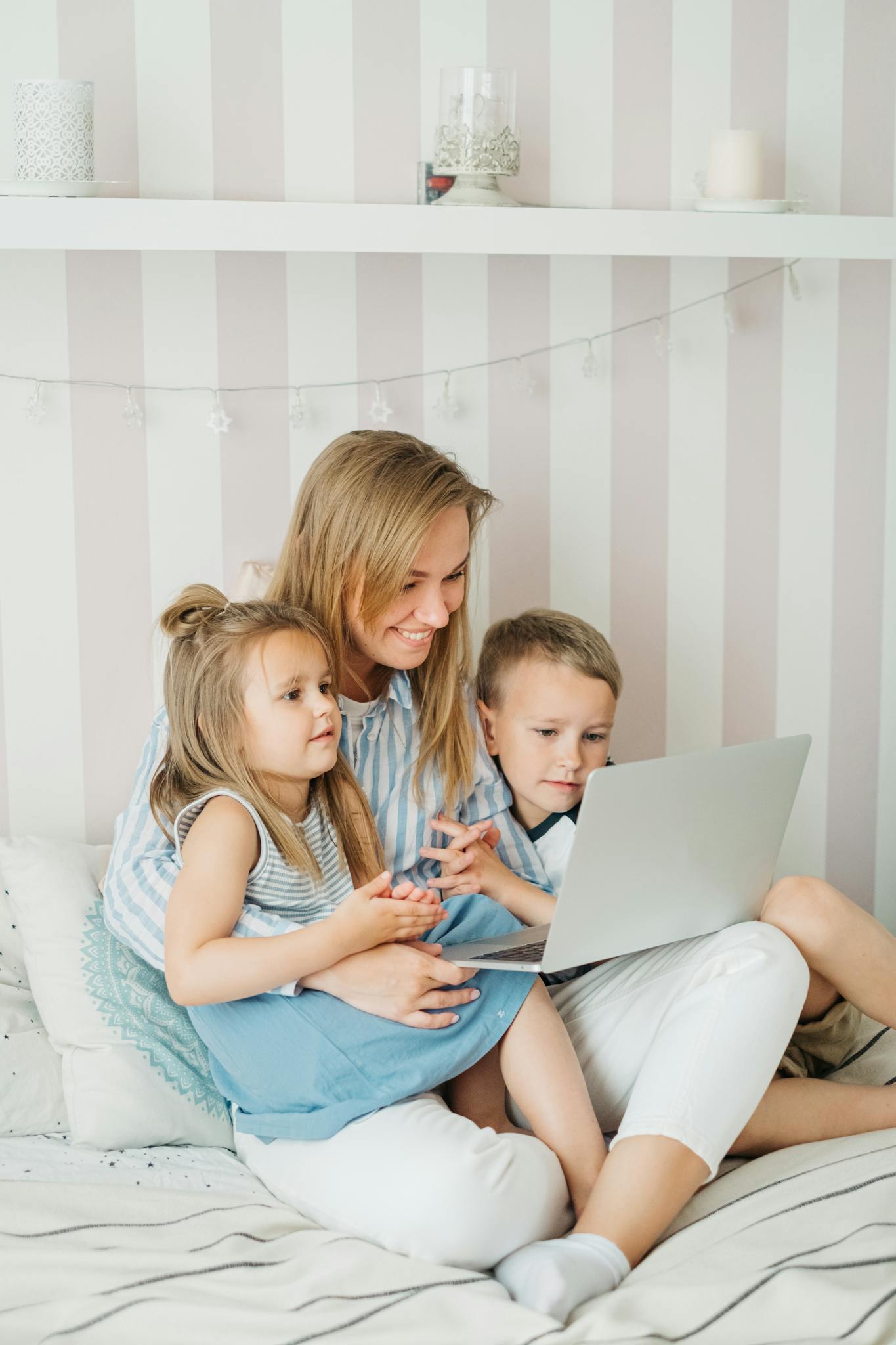Mother and children bonding over a laptop in a cozy home setting.